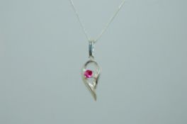 A vintage sterling silver pendant necklace with silver swirl pendant set with pink stone.