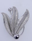 A 1950s white metal spray brooch with foliate vine decoration with roller clasp. Measures 6cms.