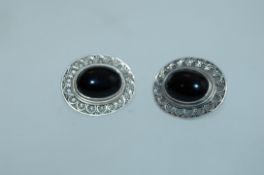 A pair of large 925 silver filigree earrings set with a large central black onyx cabochon and push