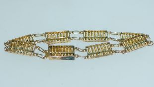 A yellow metal Hong Kong abacus bracelet with clip clasp. Marked 14 K. Likely plated. Measures 7.