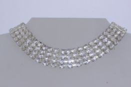 A vintage white metal diamonte choker necklace set with four strings of paste stones . Measures 16.