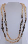A vintage agate bead necklace with yellow and white metal beads. Measures 75 inches. Weight 144g.