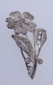 A vintage sterling silver filigree brooch in the form of a flower with roller clasp.