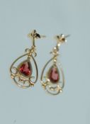 A pair of 9ct gold drop earrings with garnet in a celtic pierced drop setting no backs.