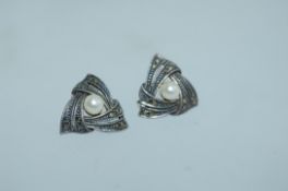 A pair of 925 silver earrings set with marcasite and central simulated pearl with push post backs.