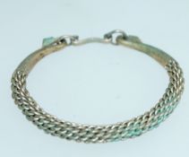 An interesting white metal bracelet of weaved form with finials fashion in the shape of fish tails