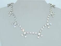 A vintage white metal necklace and earring suite consisting of paste set necklace with round claw