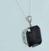 A large silver and smokey quartz pendant being claw mounted, contemporary silver chain.