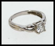 A contemporary 925 silver ring with celtic twist shoulders and central prong set clear stone.