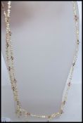 Two pearl necklaces strung with rice pearls gold beads and rose quartz. Measures 35 inches.