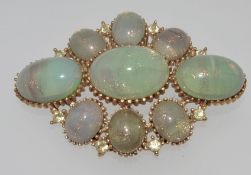 A vintage yellow metal brooch with glitter stone cabouchons and rhinestones marked for Sphinx.