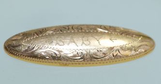 A hallmarked 9ct gold lozenge shaped christening brooch inscribed Baby within a foliate chase