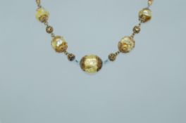 A 1930s Venetian foil lined pale yellow glass bead necklace with filigree cones and balls with oval