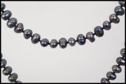 A vintage black baroque pearl necklace with knotted string. Measures 32 inches.