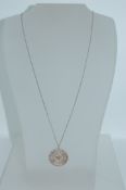 An 800 silver pendant necklace strung with a round filigree pendant on a silver chain. Marked 800.