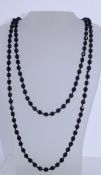 A vintage string of knotted black French jet glass beads with screw clasp. Measures 26 inches.