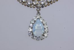 A vintage yellow metal Japanese pendant necklace set with paste stones with a pear shaped opaline