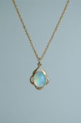 A yellow metal pendant necklace set with opal style stone with round claw clasp. Measures 18 inches.