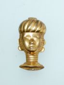 An early 20th century yellow metal Art Deco style brooch in the form of an African head with c