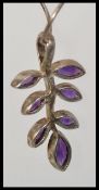 A 925 silver snake chain strung with a 925 silver Art Nouveau leaf pendant set with purple faceted