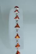 A 925 silver and amber bracelet with triangular link setting and lobster claw clasp. Measures 7.