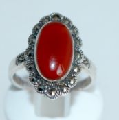 A 925 silver ring with central carnelian cabochon surrounded by a marcasite halo. Size P.