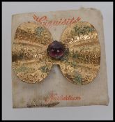 A large 1920s bow brooch with central cabochon stone with embossed ivy decoration with c clasp on