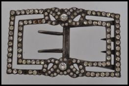 A large early 20th century white metal buckle set with paste stones and floral motif with single