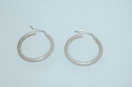 A pair of Italian 925 silver hoop earrings with planished decoration and lever clip backs.