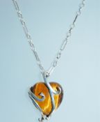 A 925 silver pendant necklace set with a large tigers eye heart shaped cabochon with silver swirl