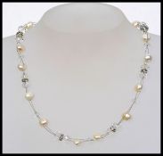 A contemporary pearl necklace strung with faceted glass beads interspaced with diamonte and pearls.