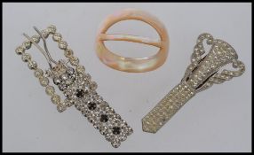An early 20th century mother of pearl buckle together with a white metal paste set buckle and a