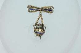 A vintage yellow metal filigree and enamel brooch with drop caldron pendant with c clasp.