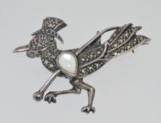 A vintage 925 silver marcasite brooch in the form of a crow with a red stone eye wearing a top hat