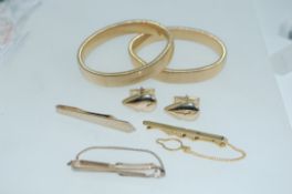 A pair of vintage yellow metal shirt cuffs together with three yellow metal tie clips and a pair