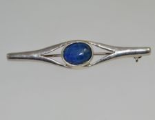A vintage silver Art Nouveau style bar brooch with a central lapis lazuli cabochon stone with