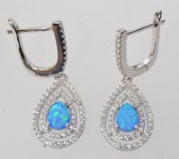 A pair of 925 silver earrings set with an opalite and twin halo CZ in a tear drop shape.