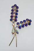 A large vintage yellow metal spray brooch set with white and purple Aurora Borealis rhinestones