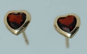 A pair of 9ct gold stud earrings with garnet stones no backs.