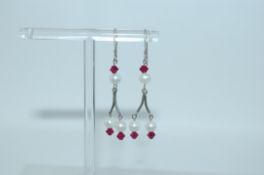 A pair of 925 silver earrings with pearl and red glass drops with fishhook backs.