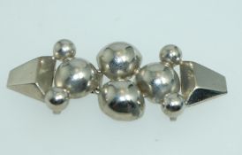 A 1930s Art Deco white metal cloak cape clip clasp with geometric ball decoration.