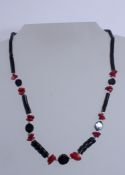 A red and black coral bead necklace with crew clasp. Measures 18 inches. Weight 10.