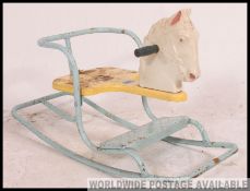 An original vintage Triang rocking horse, of tubular metal form with a cream plastic seat.