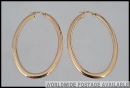 A pair of large Italian designer hallmarked 9ct gold hoop earrings with post clip clasps.