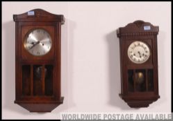 A French early 20th century oak cased wal clock with decorative silver dial and pendulum window