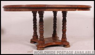 An antique style oak extending dining table raised on turned legs with extending centre.