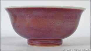 A Chinese monochrome ochre red bowl with white glaze border bearing twin blue concentric circles to