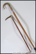 A silver collared horn cane riding crop along with a silver collared horn handled walking stick