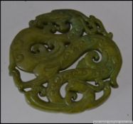 A well carved Chinese jade Bi / roundel of circular form depicting dragons L7cm