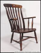 A Victorian 19th century elm and beech Windsor high back elbow chair united by turned stretchers